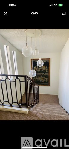 A staircase with a carpeted runner and a metal railing.