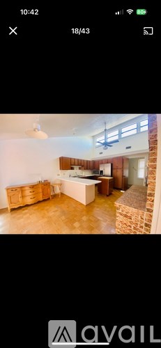 A room with wooden floors and a brick wall.