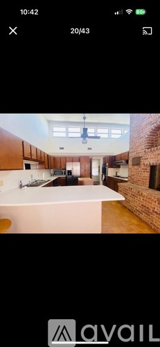 A modern kitchen with wooden cabinets and a brick wall.