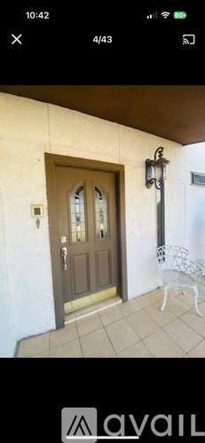 A brown door with a glass window is on a white wall.
