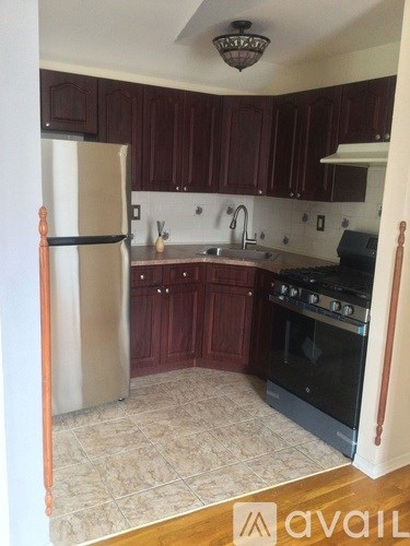 A kitchen with dark wood cabinets and a white fridge.