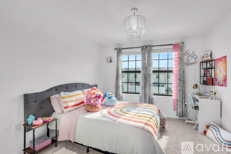 A bedroom with a large bed and a window with curtains.