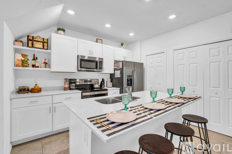 A modern kitchen with white cabinets and a central island.