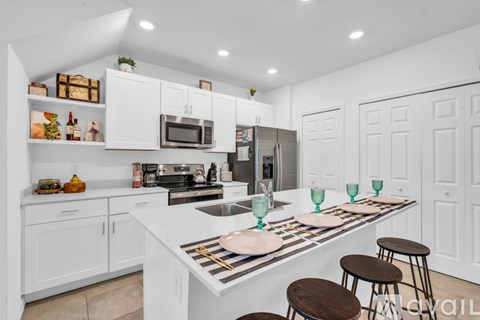 A modern kitchen with white cabinets and a central island.
