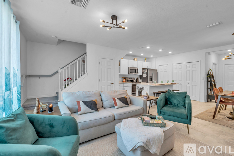 A living room with a white couch and a green armchair.
