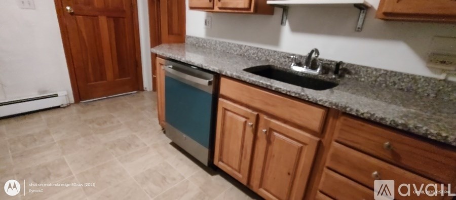 A kitchen with a granite countertop and wooden cabinets.