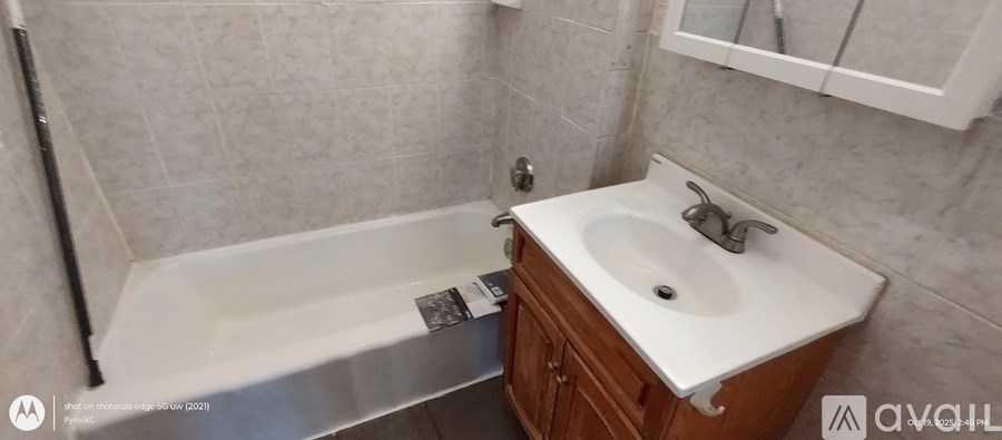 A white sink is on a wooden cabinet in a bathroom.