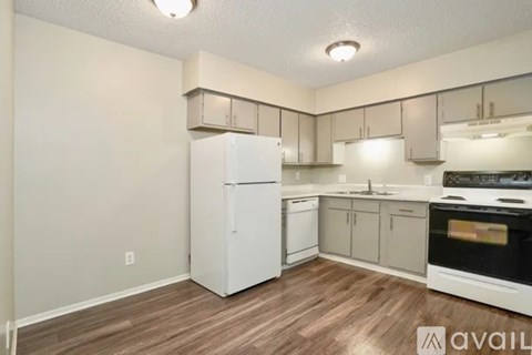 A kitchen with white appliances and wooden floors.