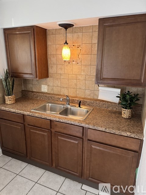 A kitchen with brown cabinets and a tiled backsplash.