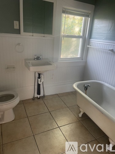 A white bathroom with a toilet, sink, and bathtub.