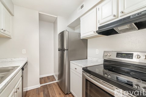 A kitchen with white cabinets and a stainless steel refrigerator.