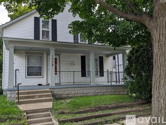 A white house with a red door and black shutters.