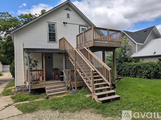 A house with a deck and stairs leading to the second floor.