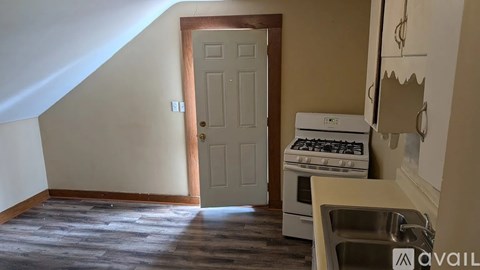 A kitchen with a stove and a door in the background.