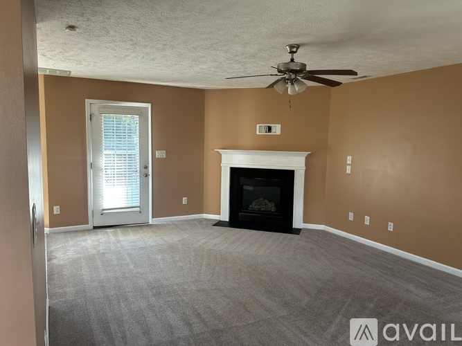 A living room with a fireplace and a ceiling fan.