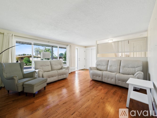 A living room with wooden floors and a large window.