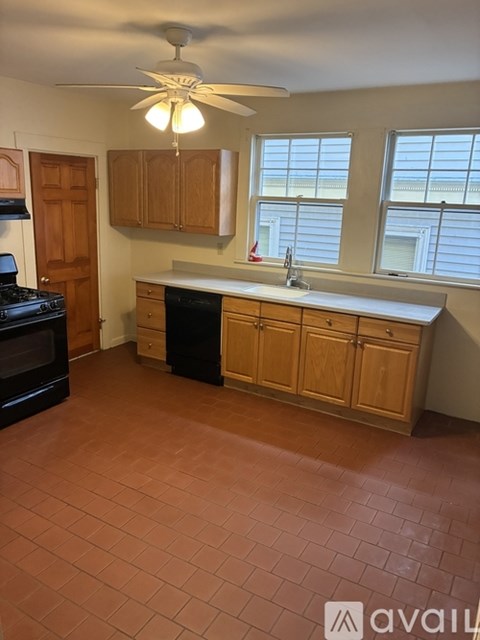 A kitchen with a black stove top oven and a white sink.