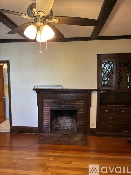 A fireplace with a wood mantle and a fan above it.