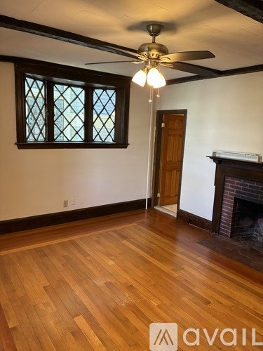 A room with wooden floors and a ceiling fan.