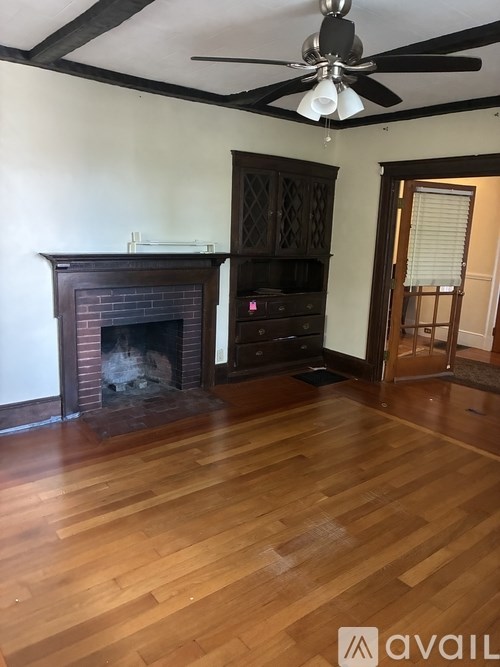 A room with a fireplace and wooden floors.