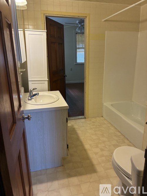 A bathroom with a sink, toilet, and bathtub.