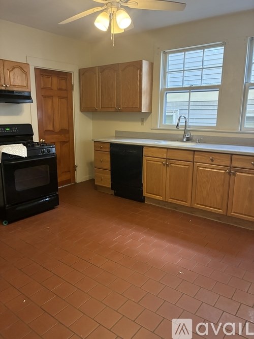 A kitchen with black appliances and wooden cabinets.