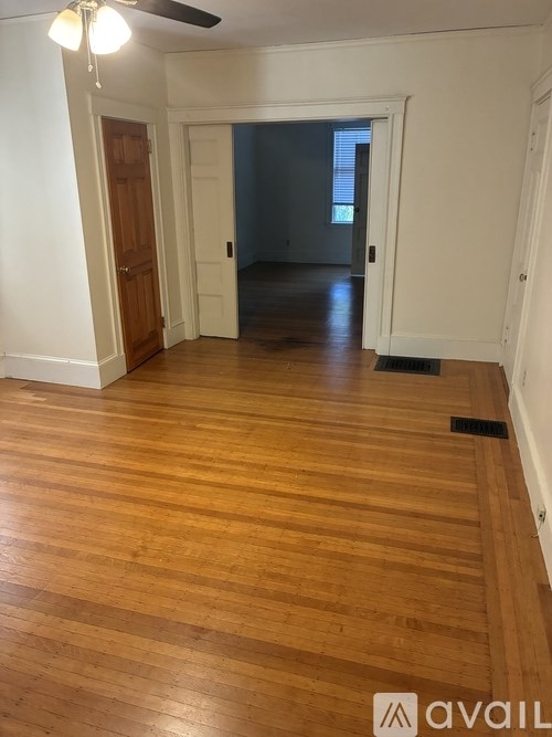 A room with wooden floors and a ceiling fan.