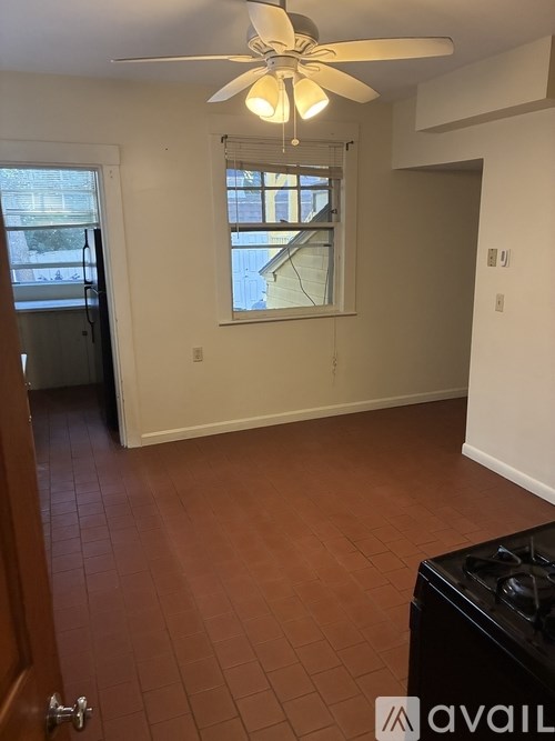 A room with a black stove and brown tiled flooring.