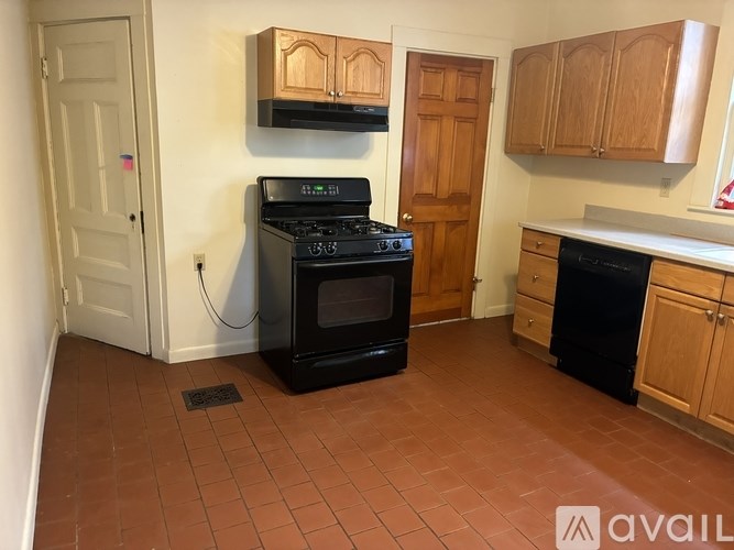 A black oven with a digital display is in a kitchen with brown tiles.