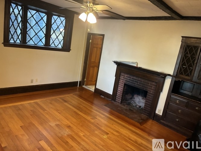 A room with a fireplace and wooden floors.