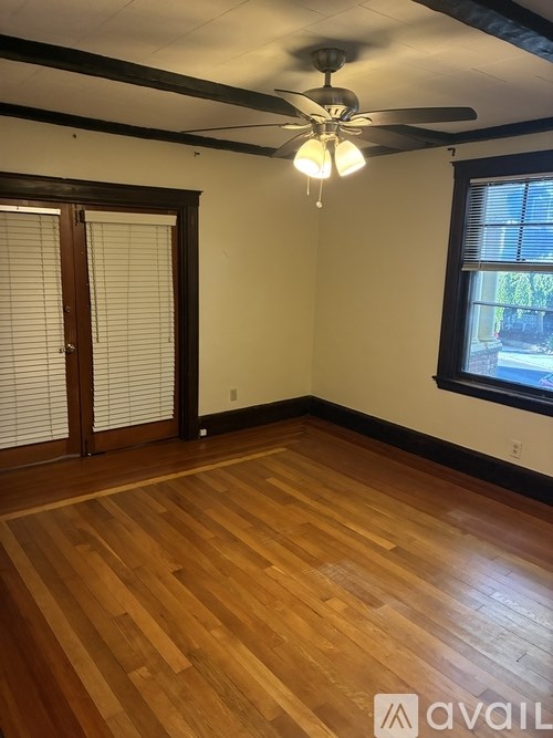 A room with wooden floors and a ceiling fan.