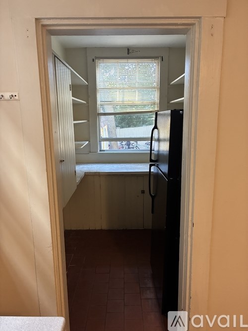 A small kitchen with a refrigerator and a window.