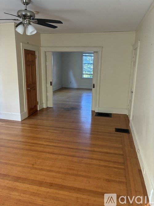 A room with wooden floors and a ceiling fan.