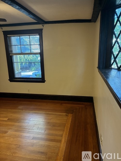 A room with a window and wooden flooring.