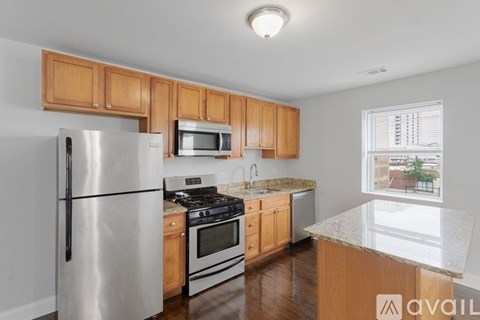 A kitchen with wooden cabinets and a stainless steel refrigerator.