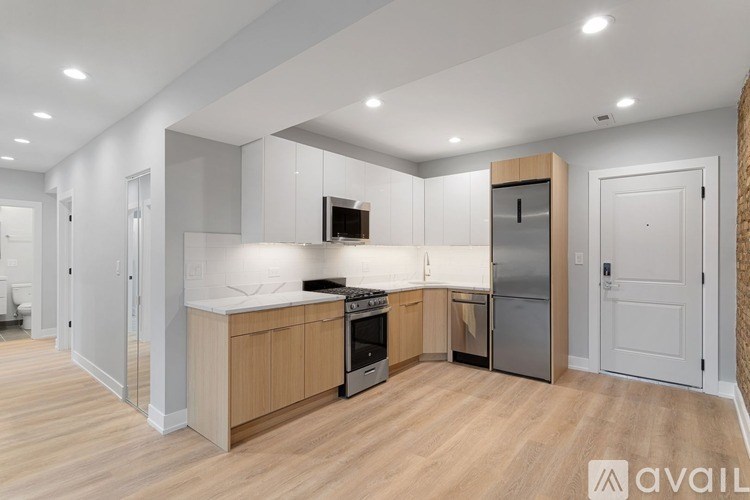 A modern kitchen with wooden floors and white walls.