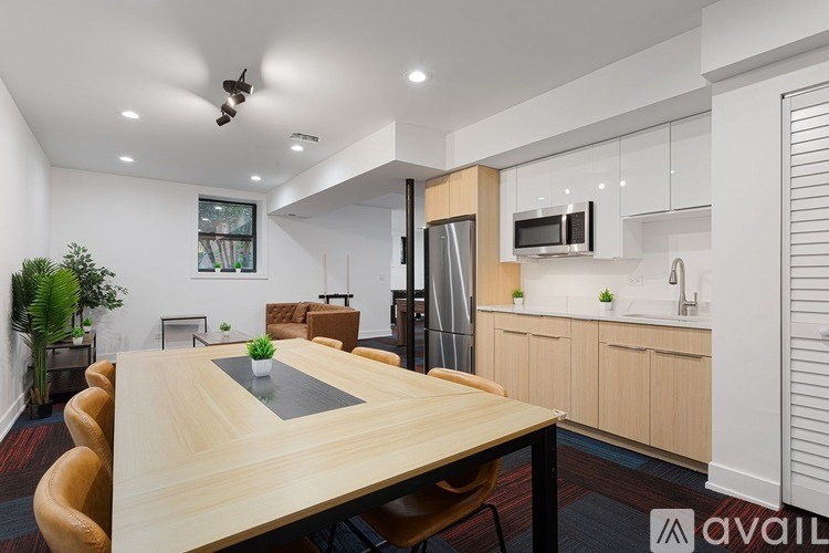 A modern kitchen with a wooden table and chairs in the foreground.