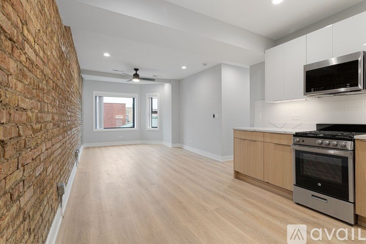 A kitchen with a brick wall and wooden floors.