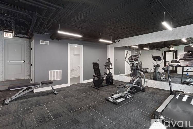 A gym with treadmills, exercise bikes, and weights.
