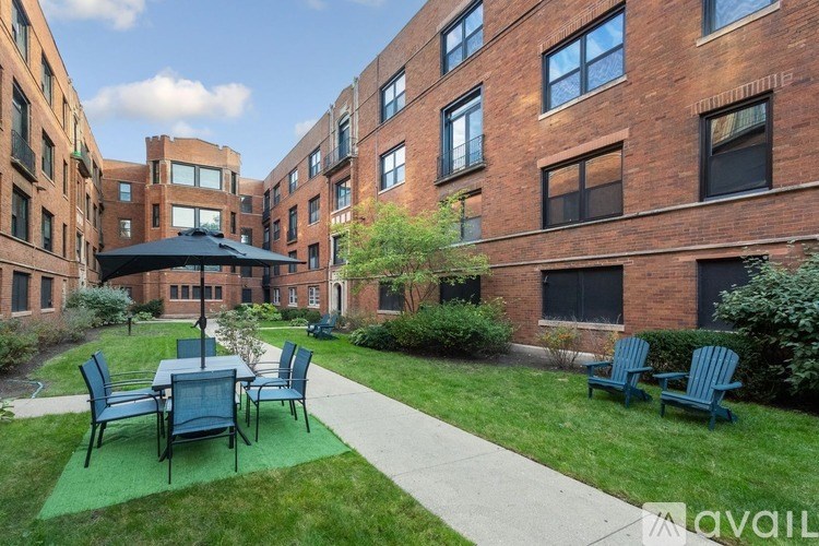 A patio with a table and chairs is surrounded by brick buildings.