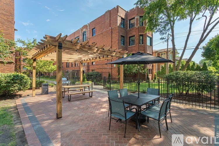 A patio with a table and chairs under a pergola.
