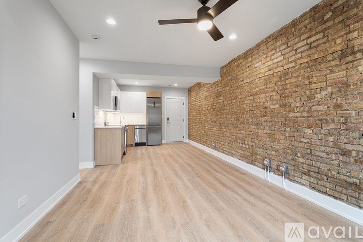 A room with a brick wall and wooden flooring.