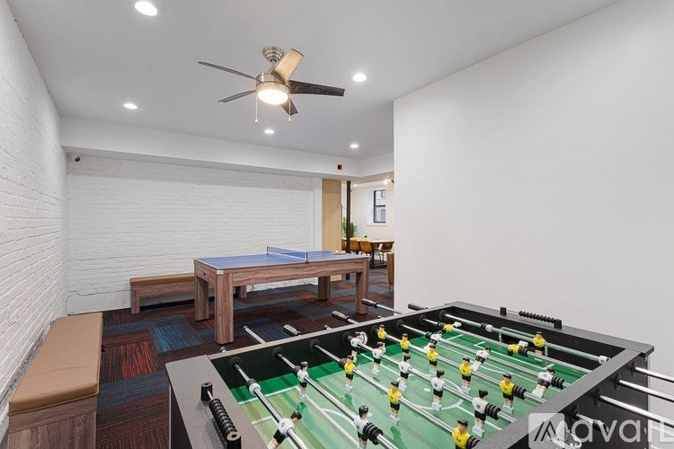 A foosball table is in the middle of a room with a dining table and chairs.