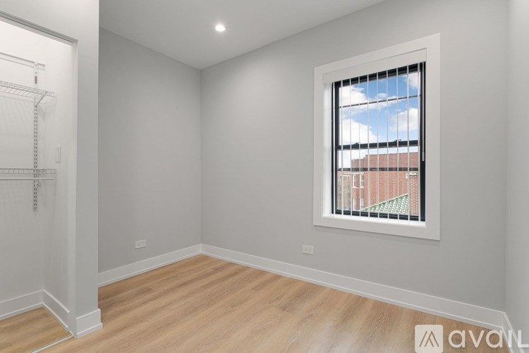 A room with a window showing a red building outside.