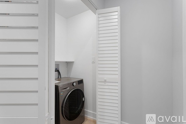 A washing machine is in a small, white room.