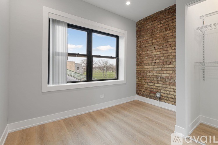 A room with a large window and a brick wall.