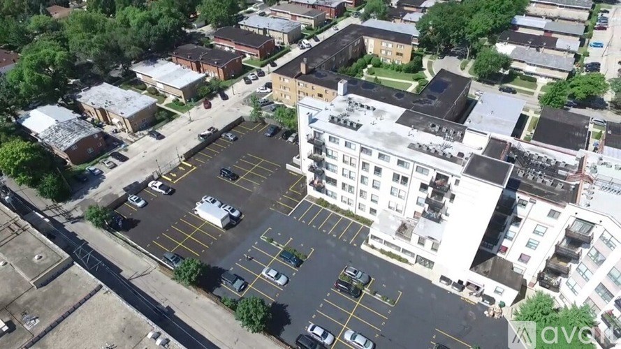 A parking lot with cars and a white building in the background.