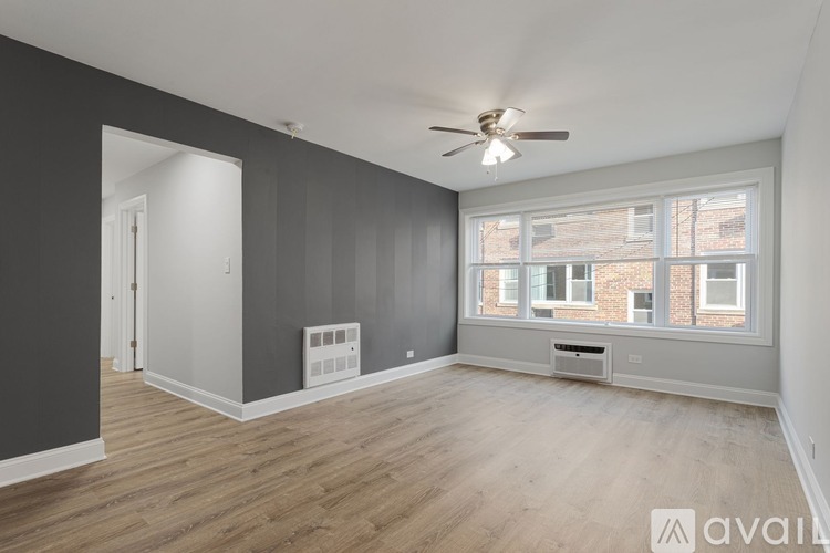 A spacious room with a ceiling fan and large windows.