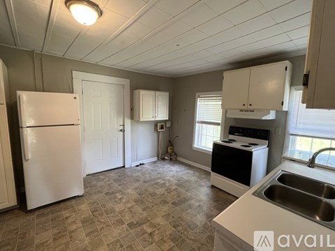 A kitchen with a white refrigerator, a black dishwasher, and a sink.