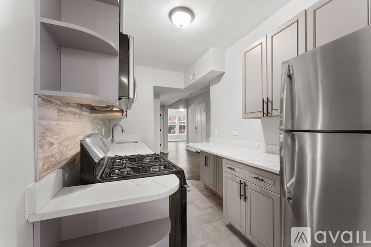 A modern kitchen with a stove top oven and a refrigerator.